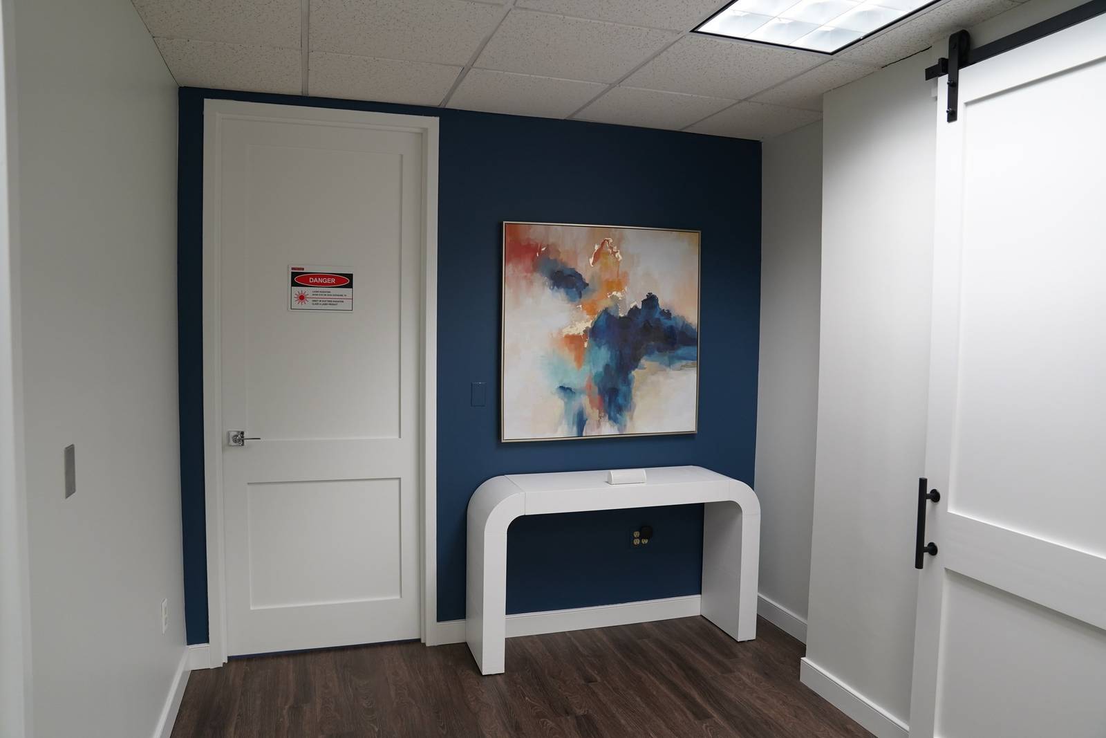 A hallway with a navy wall and abstract art