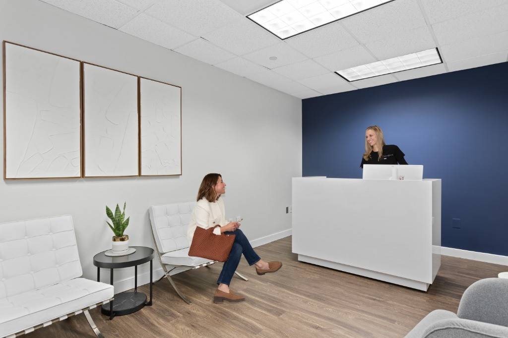 The reception at Virginia Laser Specialists in Vienna, VA, with the navy wall behind the desk