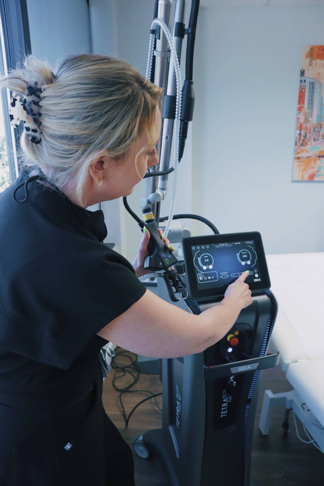 A practitioner using the touchscreen of the Tetra Pro CO2 laser
