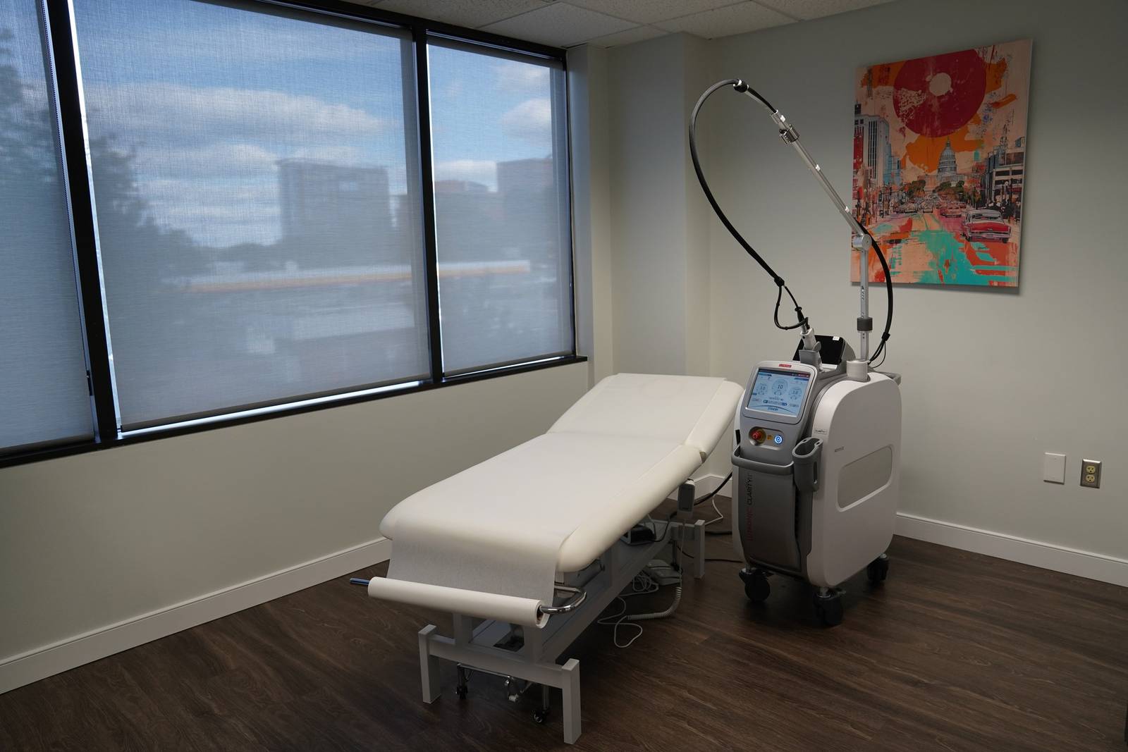 A bright treatment room with large windows and the Clarity II laser at Virginia Laser Specialists